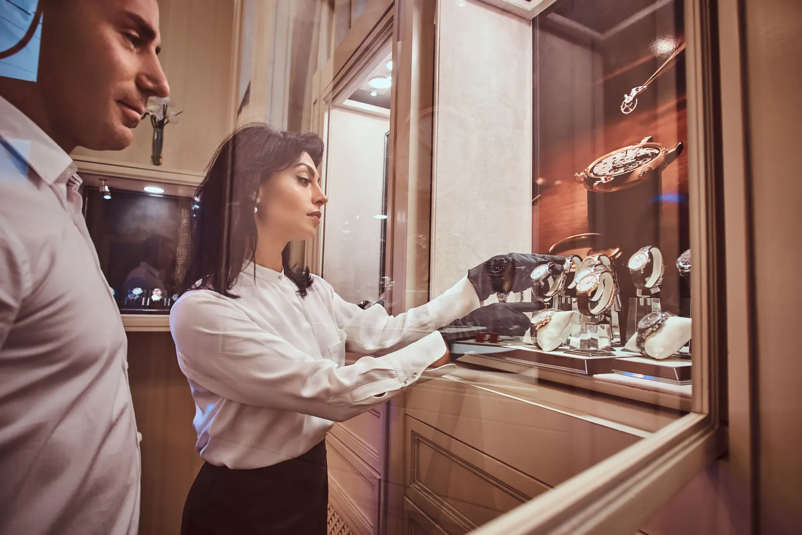 Seller showing a client a men's watch in a watch store, best watch brands