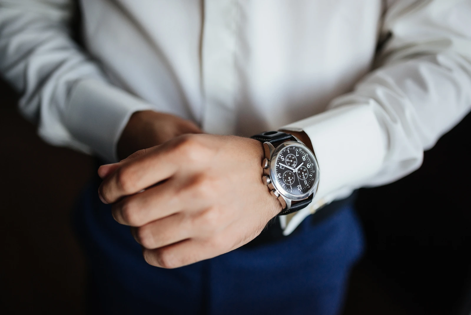 Man fastening a steel wristwatch, a classic look for German watch brands