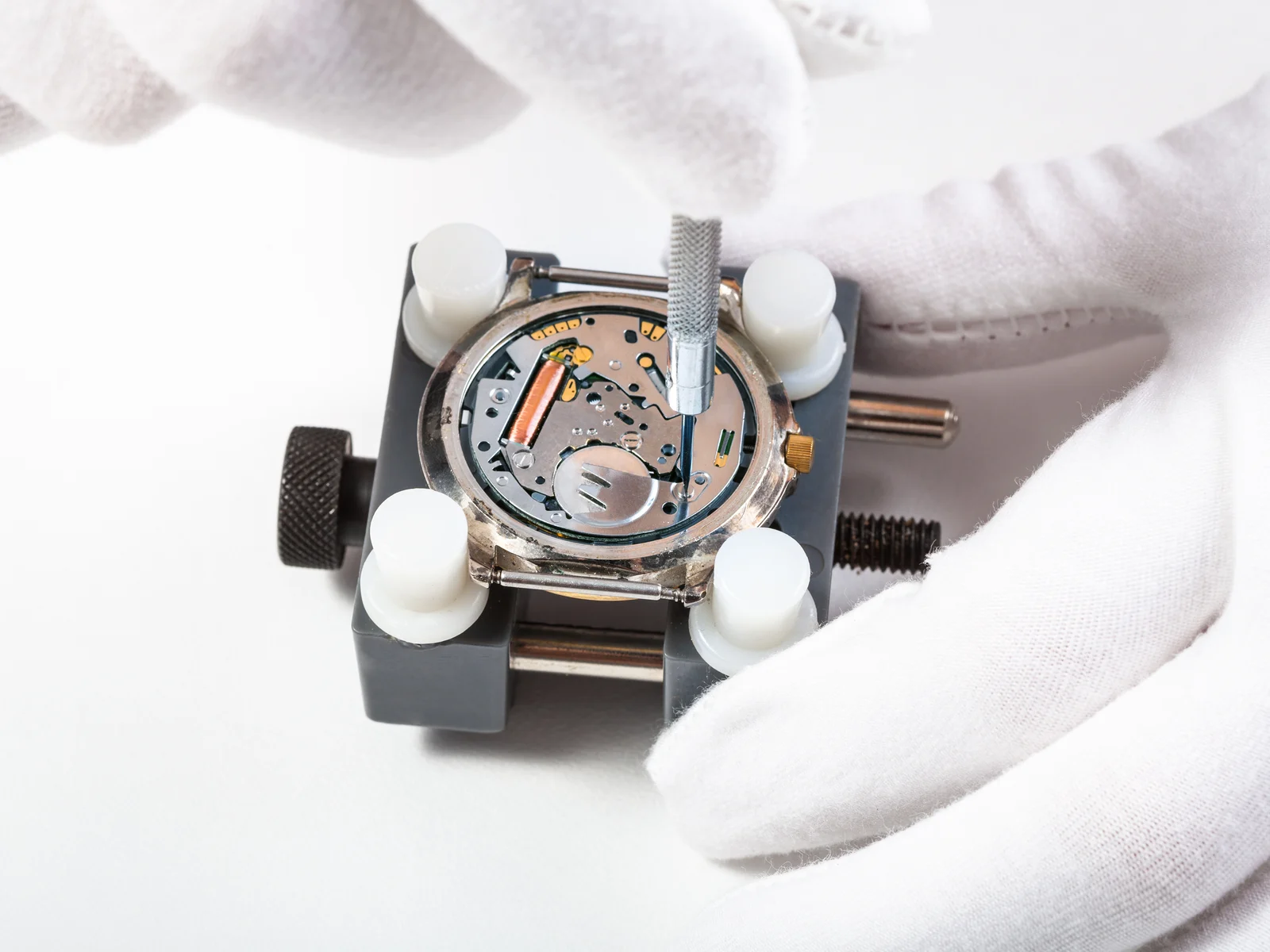 Quartz watch movement in a holder with a precision screwdriver